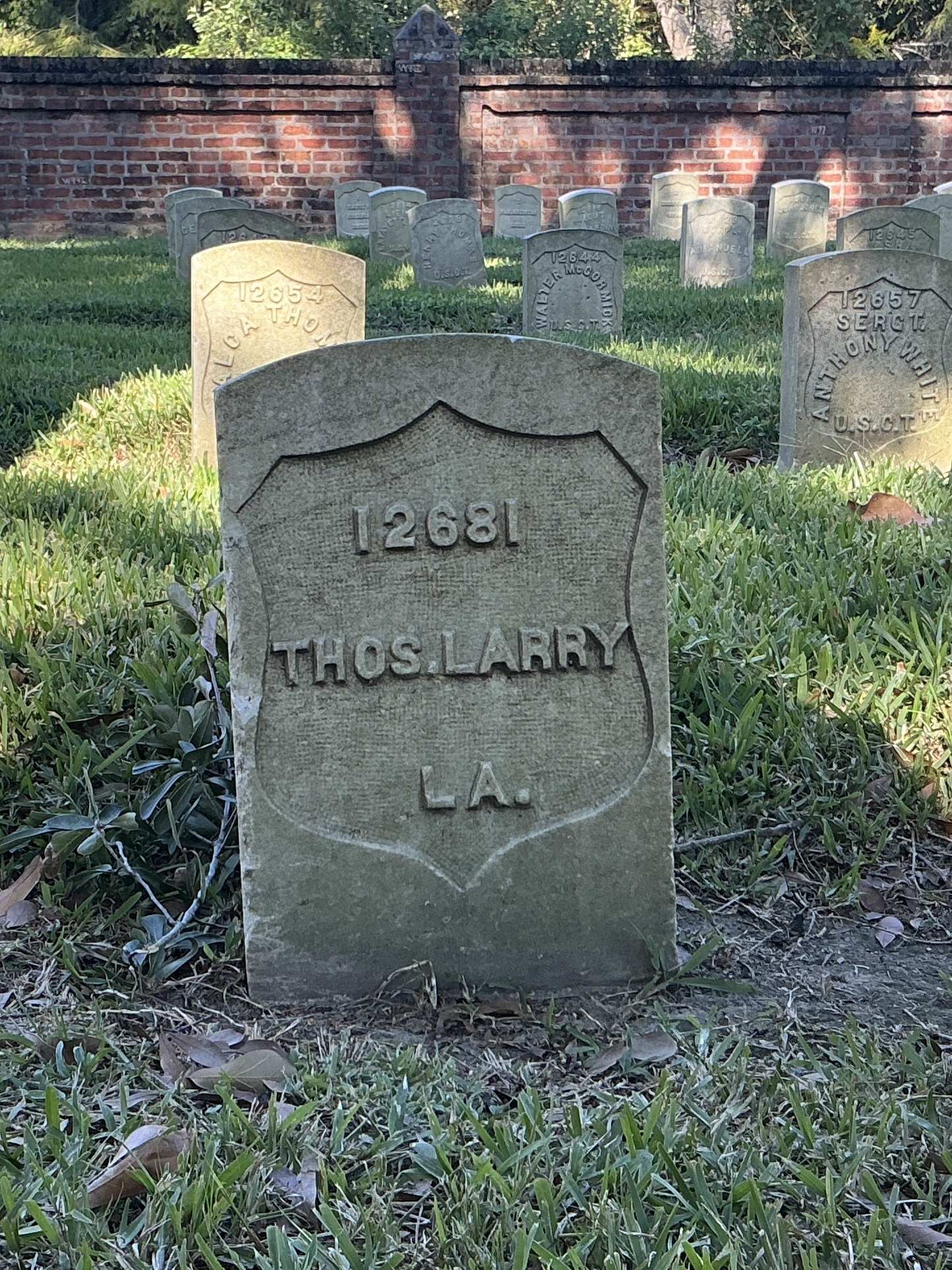 Front of historic upright marble headstone with recessed shield face.