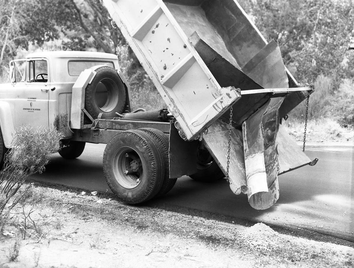 Road maintenance - gravel spreader dump truck with truck bed fully raised.