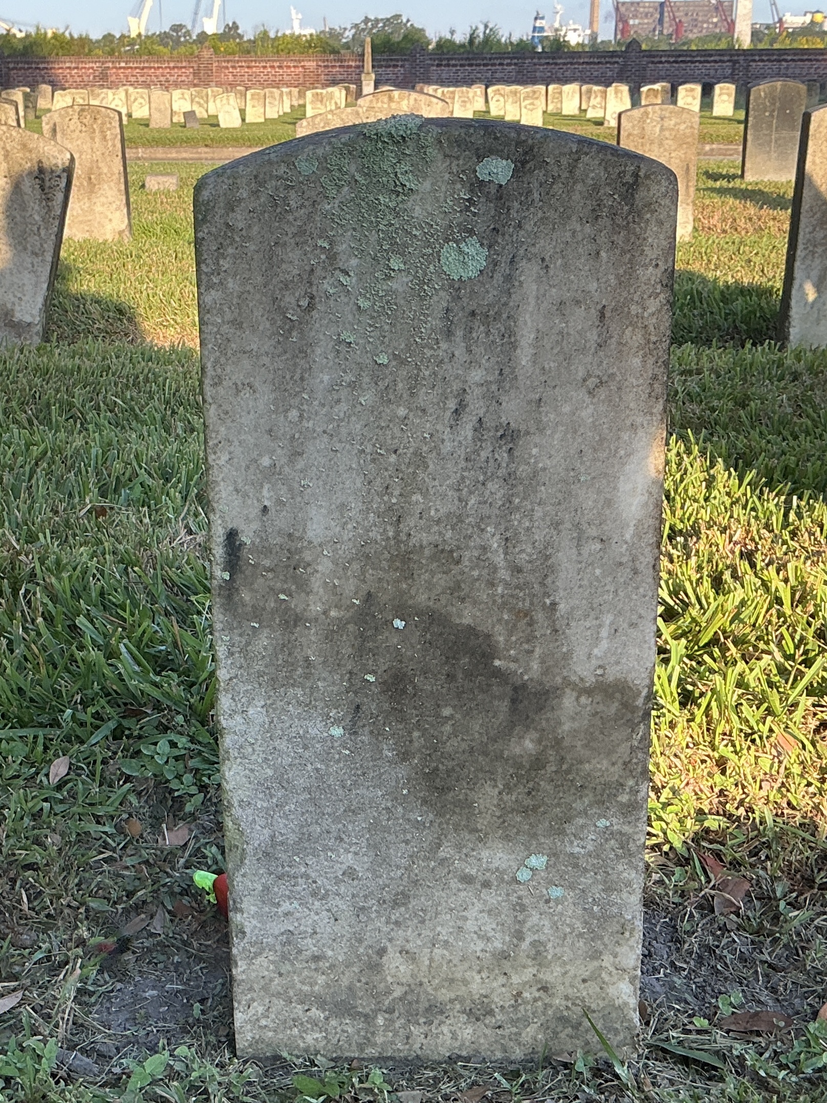 Back of historic upright marble headstone with recessed shield with recessed lettering face.