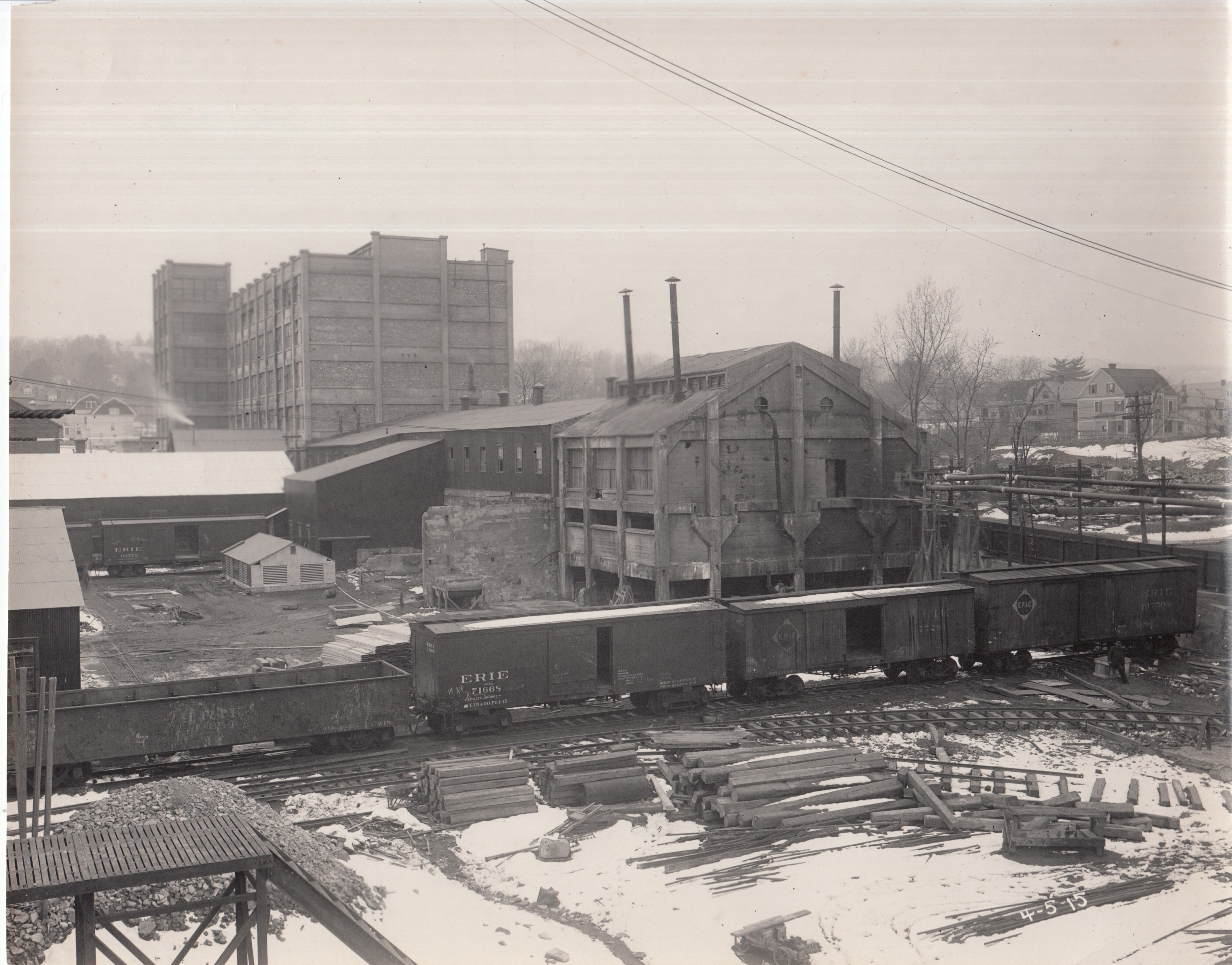 View of Edison works, Building 24 in background. Erie railroad cars in foreground.