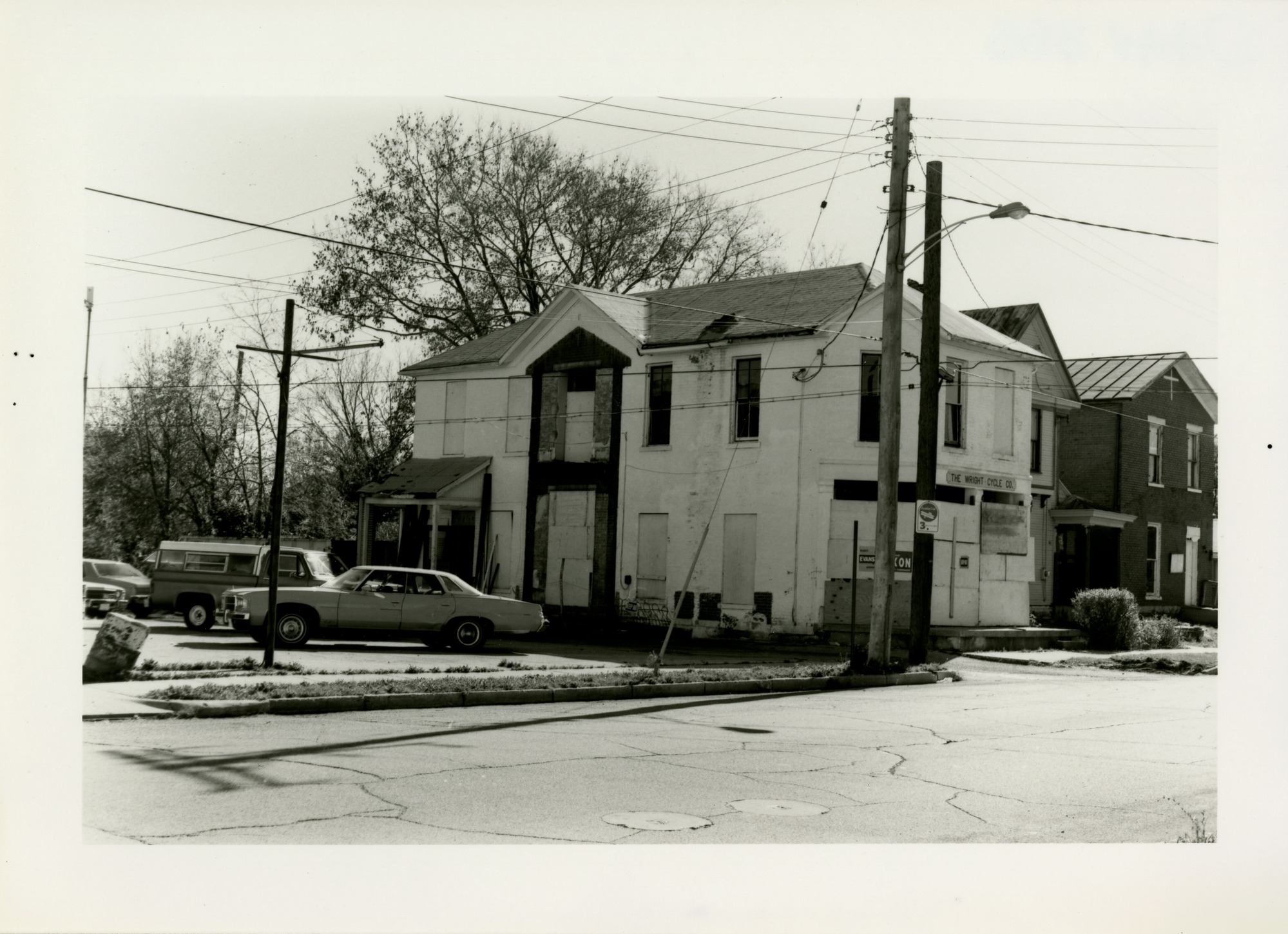Side view of the Wright Cycle Company from street with cars parked outside