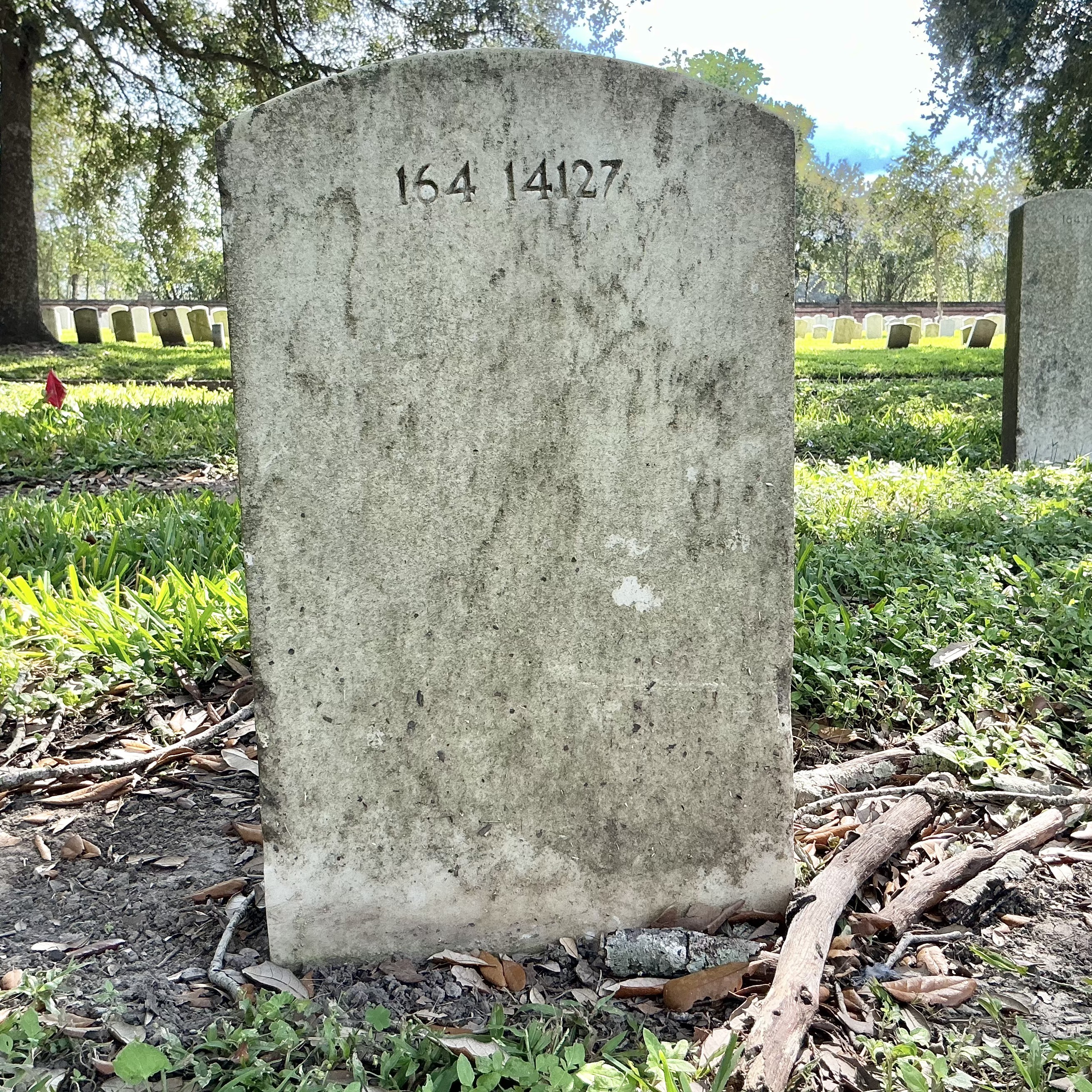 Back of upright marble headstone with flat face.