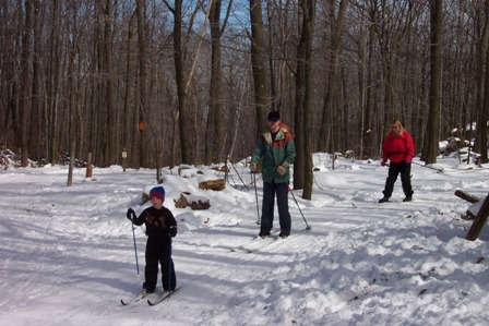 A family skis on a trail in Laurel Ridge State Park