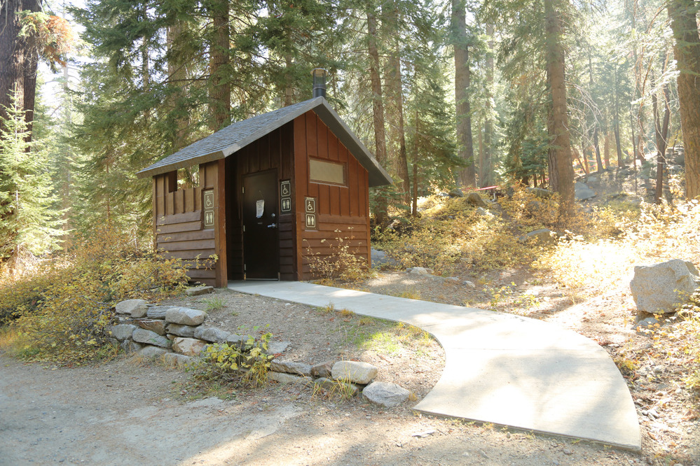 Single extra wide vault toilet with paved ramp
