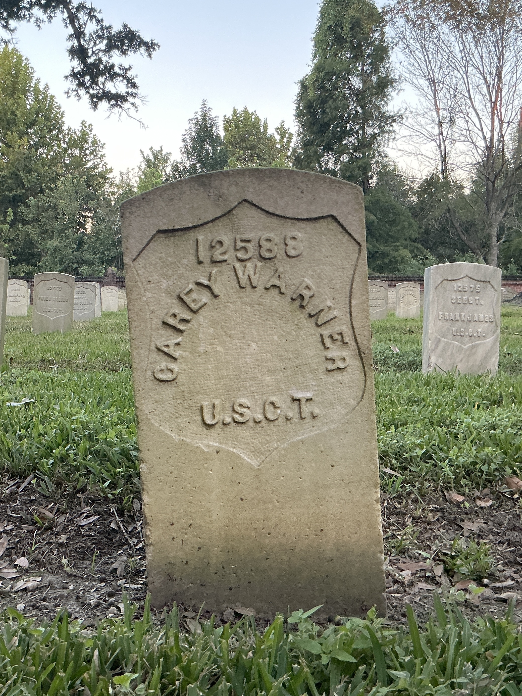 Front of historic upright marble headstone with recessed shield face.