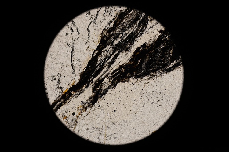 Circular microscopic image of rock structure.