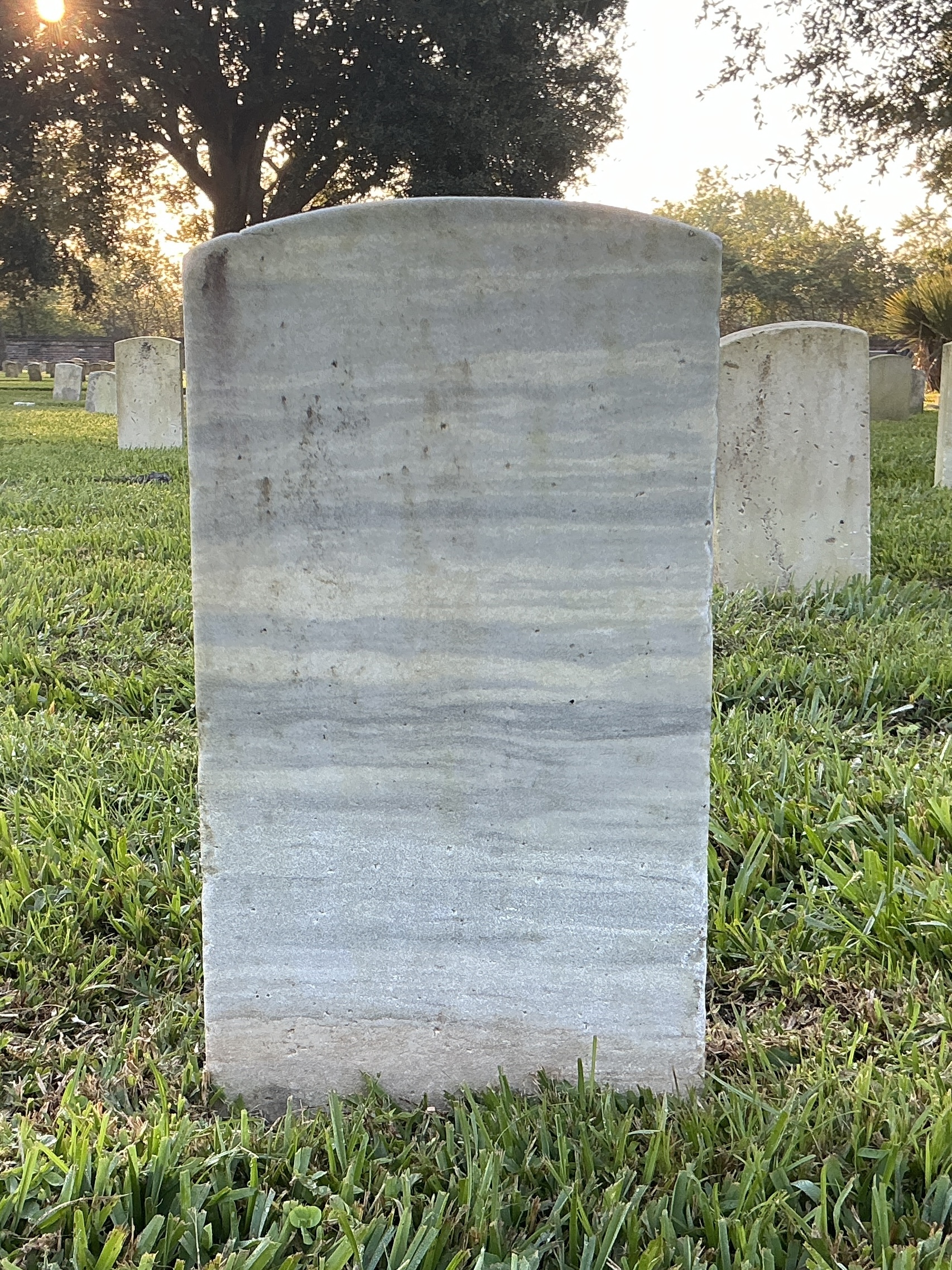 Back of historic upright marble headstone with recessed shield face.