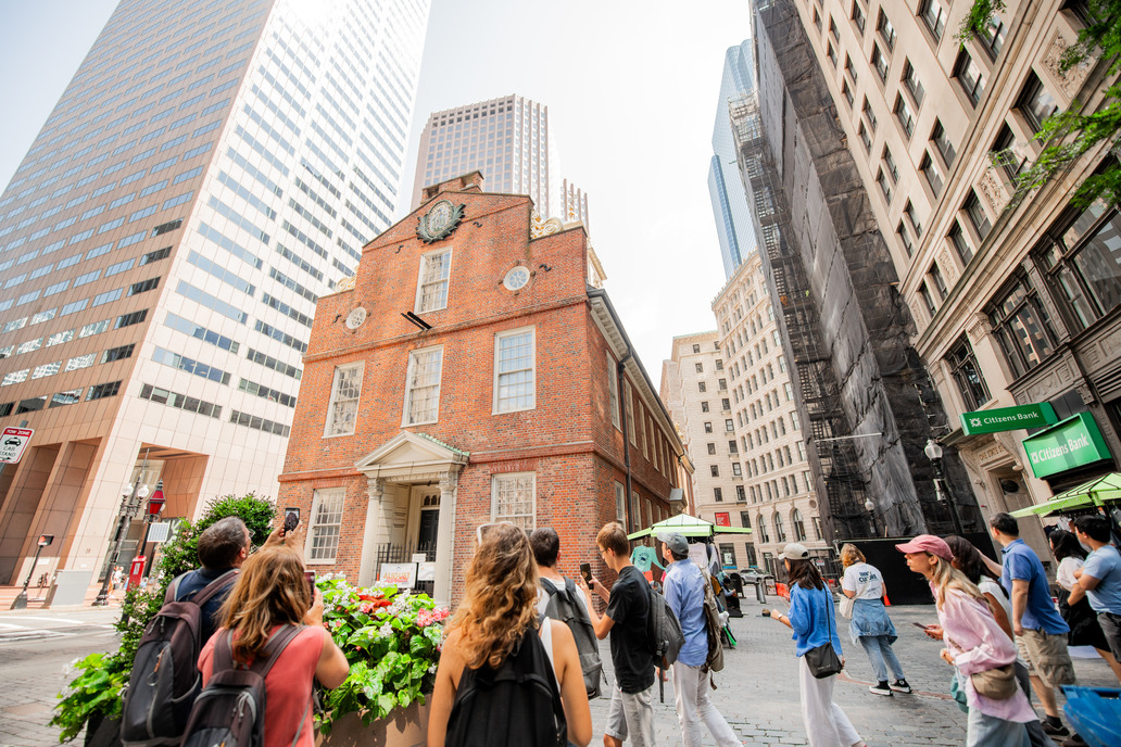 Visitors stand outside the back of the Old State House, taking pictures of the facade. 
