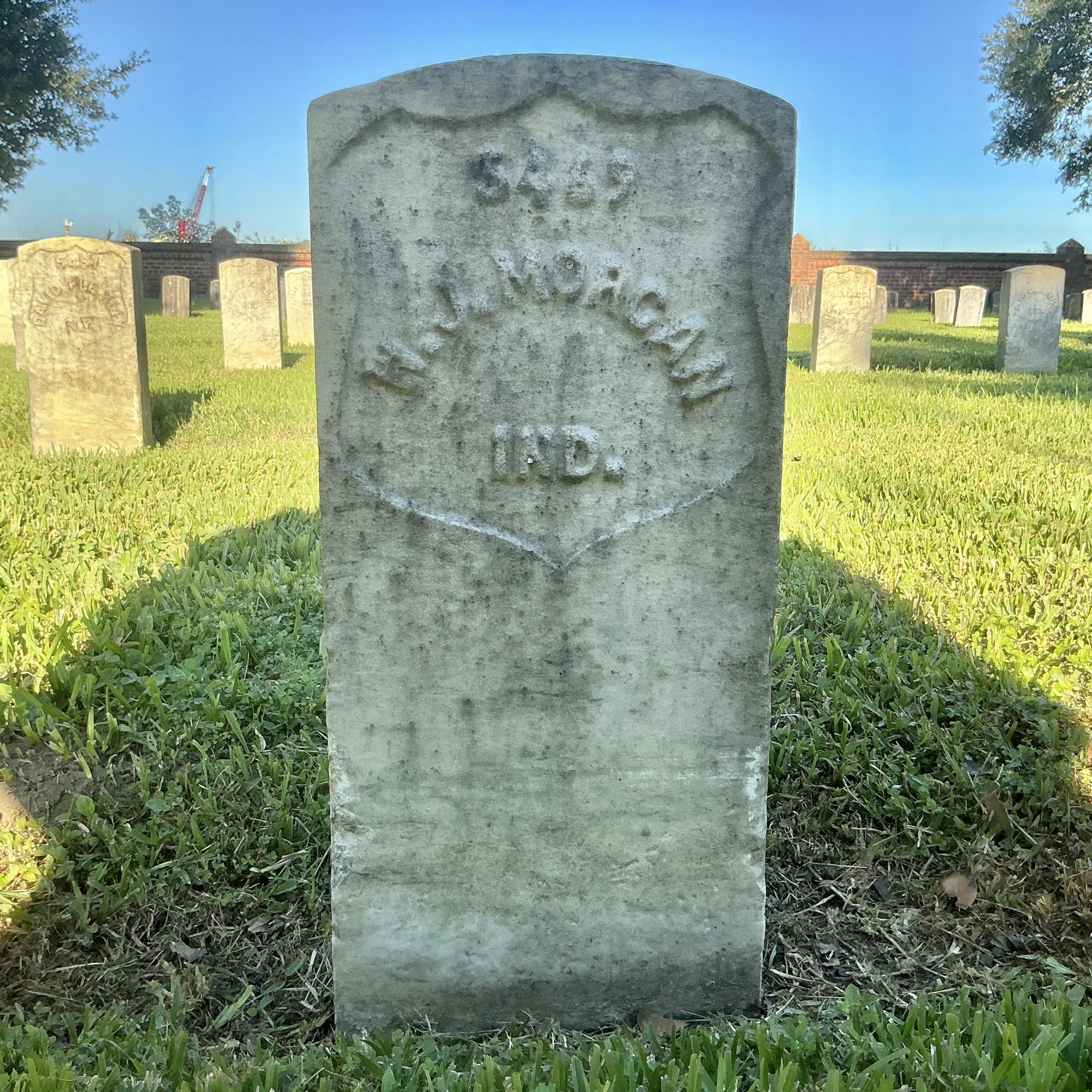 Front of historic upright marble headstone with recessed shield face.