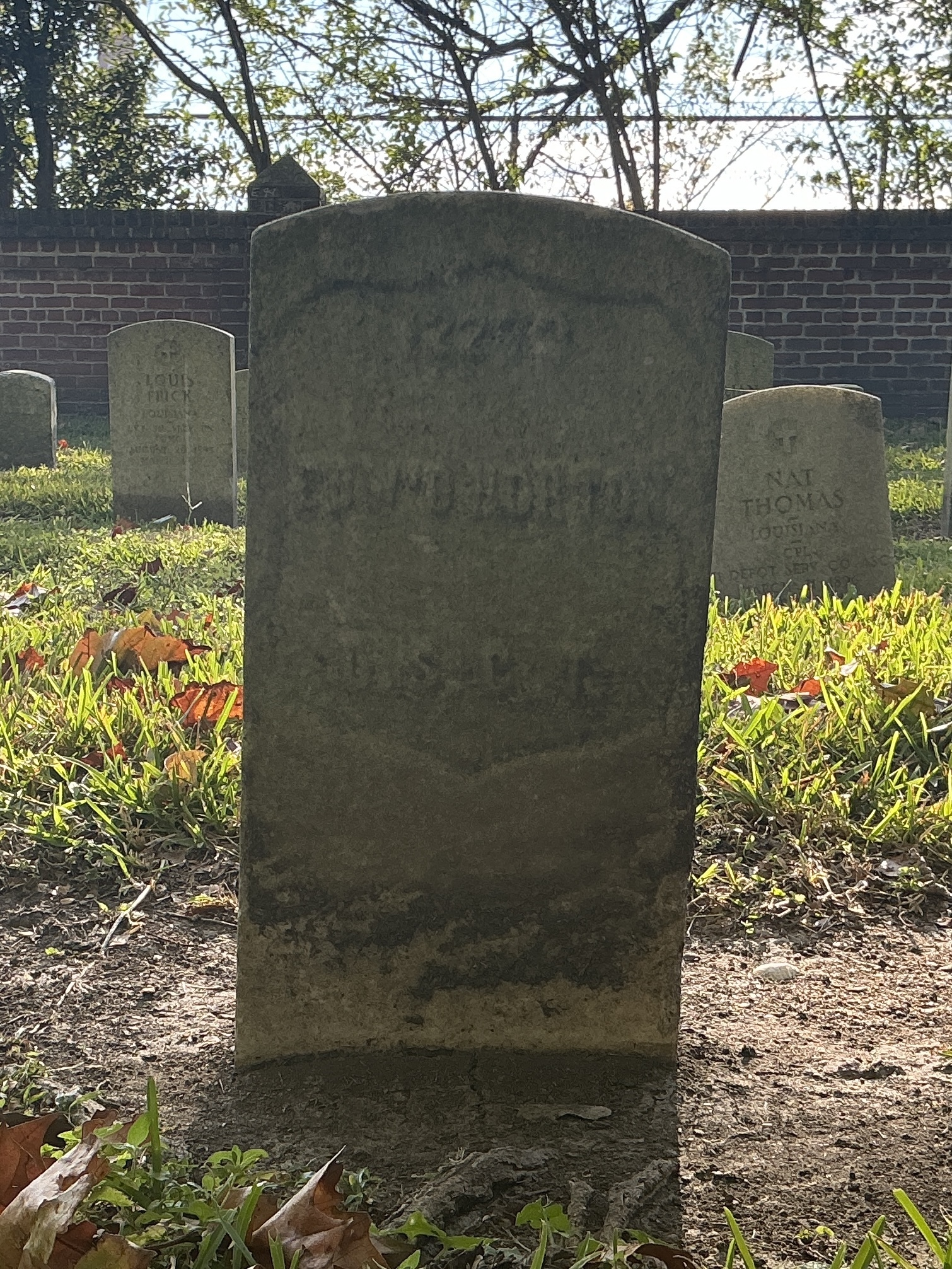 Front of historic upright marble headstone with recessed shield face.