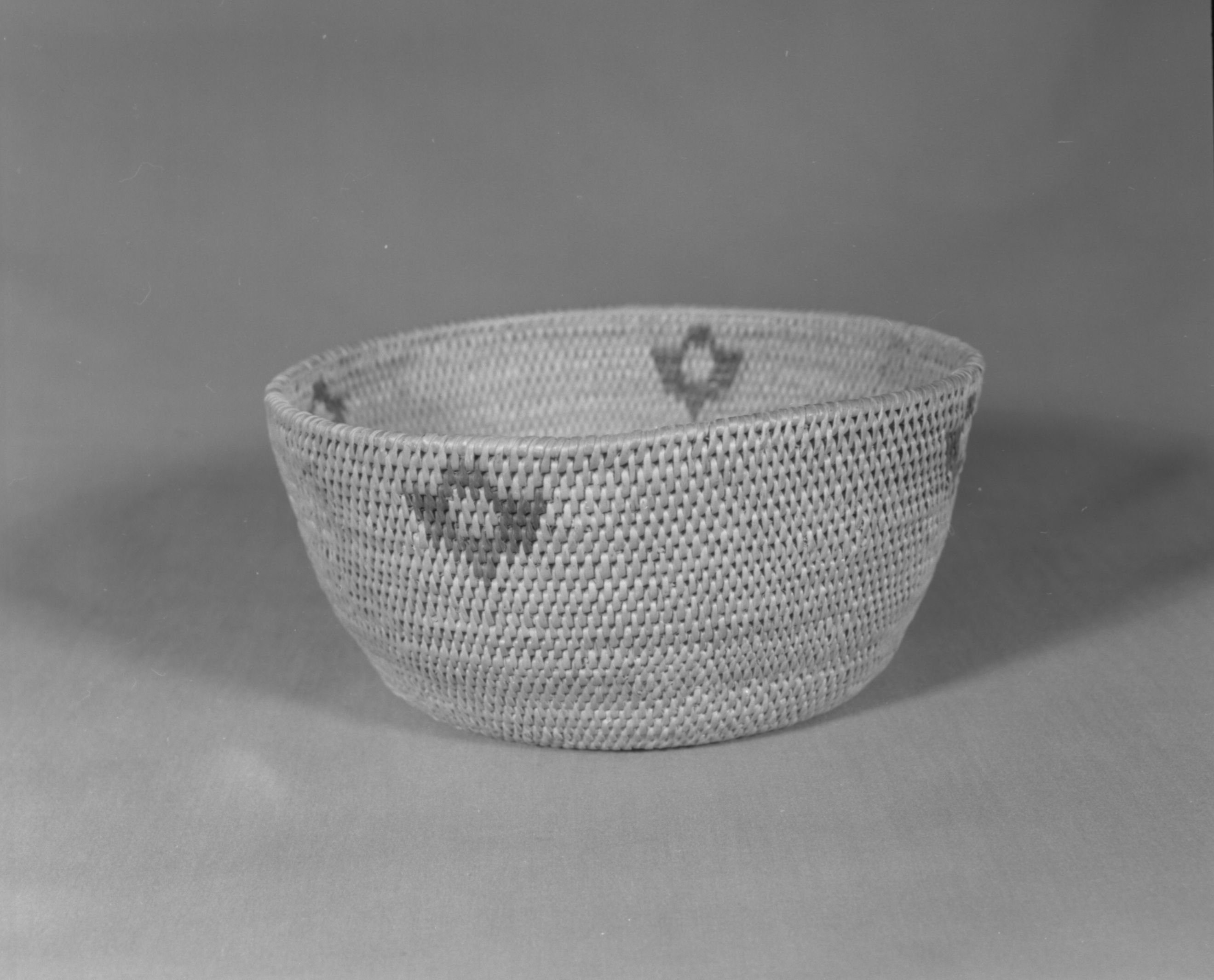 Private Collection. Object: Miwok basket. Dimensions: 8 1/4 x 4". Materials: Bull pine and bracken fern. Technology: Single rod, fag ends trimmed on work face, moving ends trimmed on interior. Leftward coil direction, rim overstitched only once. Clockspring small and neatly overstitched. Collection History: Made by Matilda, a Sonora Miwok, c. 1920. Photographed by Michael Dixon. Catalogued by Craig Bates and Barbara Beroza. Yosemite Collections, National Park Service.