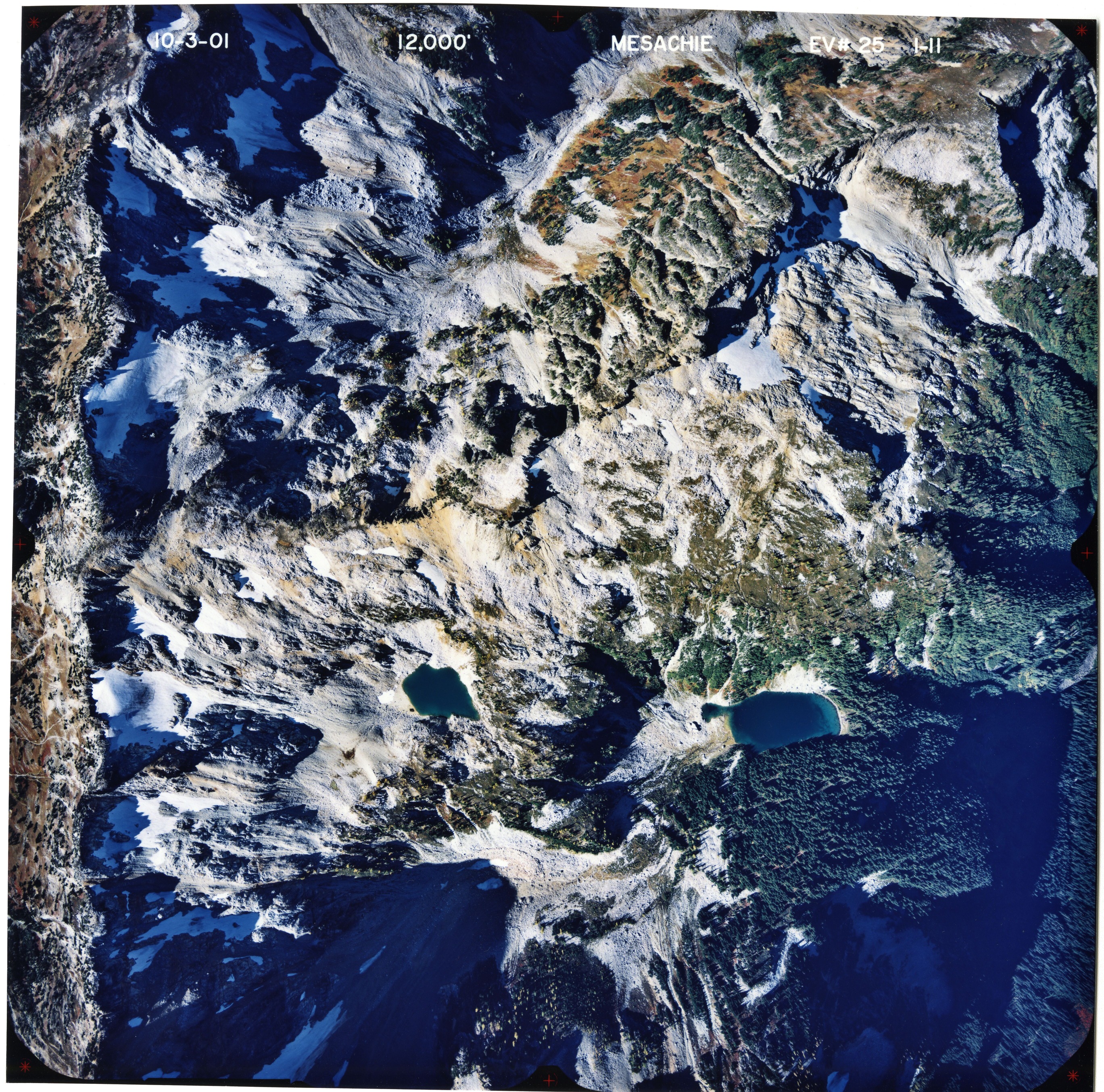 Color aerial photograph of glaciated mountain peak with forested valleys below.