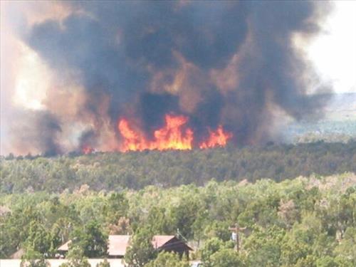 Full fire with black smoke advancing on buildings on the first day of Long Mesa Fire, Mesa Verde National Park, July 29, 2002