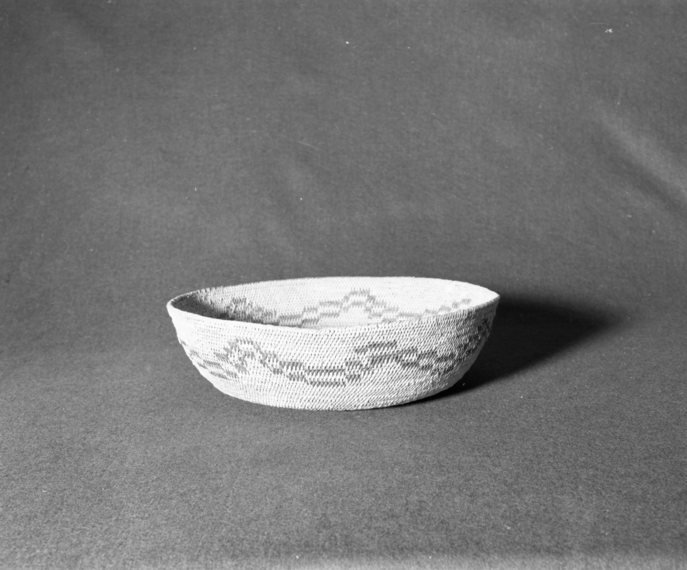Marie Rozier Collection, Catalog No. 62. Object: Miwok general receptacle basket. Dimensions: 13 1/2 x 4". Materials: split bull pine, split redbud. Technology: single rod, fag ends trimmed on workface, moving ends clipped on interior, leftward coil direction. Collection History: made at Tuolumne Reservation around 1929. Photographed by Michael Dixon, December 1982. Catalogued by Craig Bates and Barbara Beroza. Yosemite Collections, National Park Service.