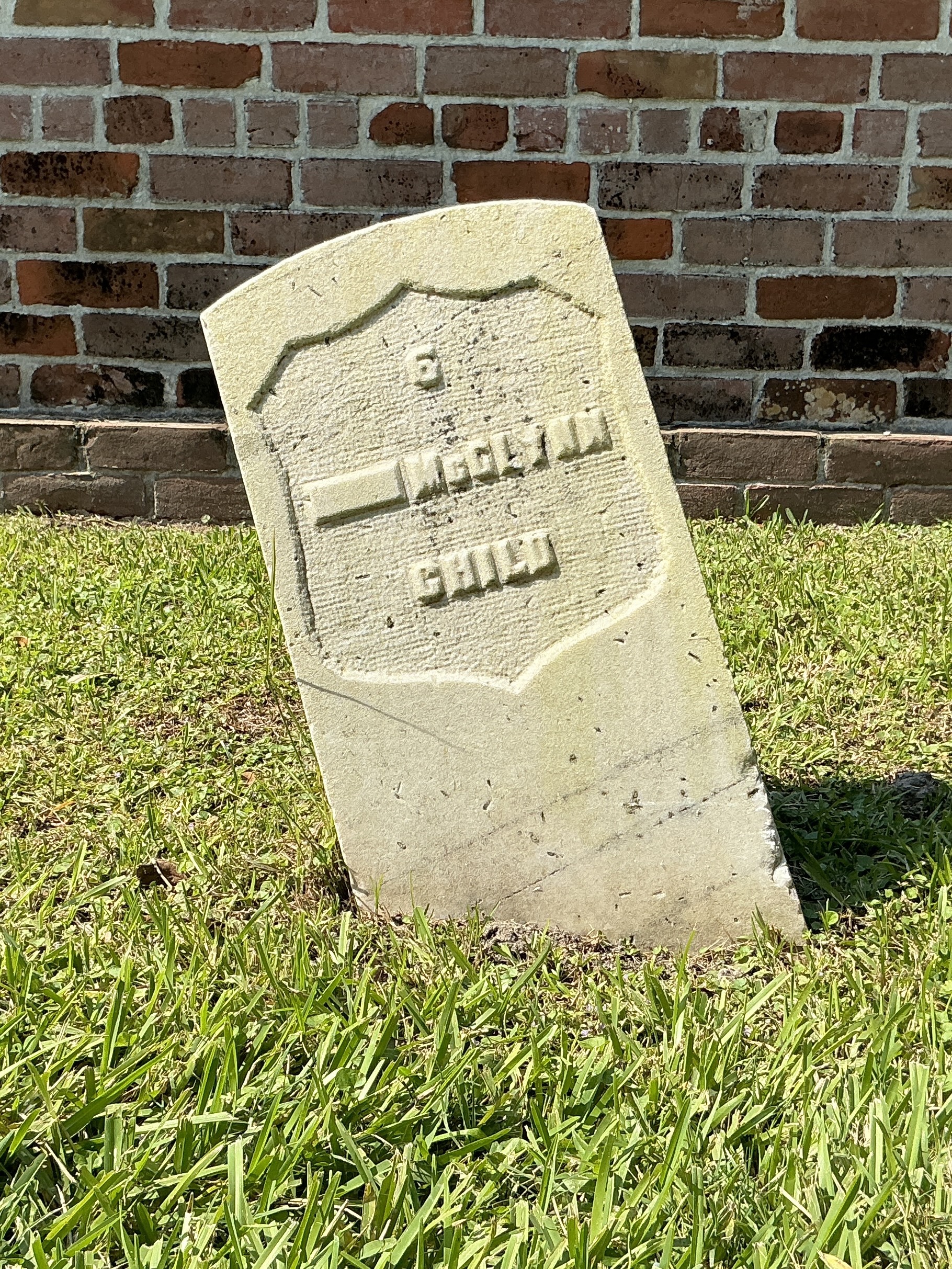 Front of historic upright marble headstone with recessed shield face.
