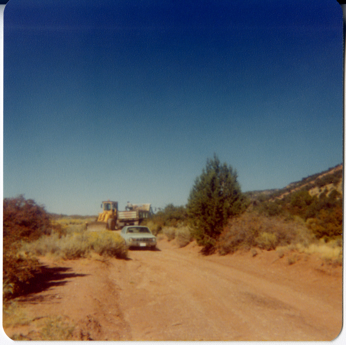 Construction vehicles driving on dirt road in Kolob Canyon.