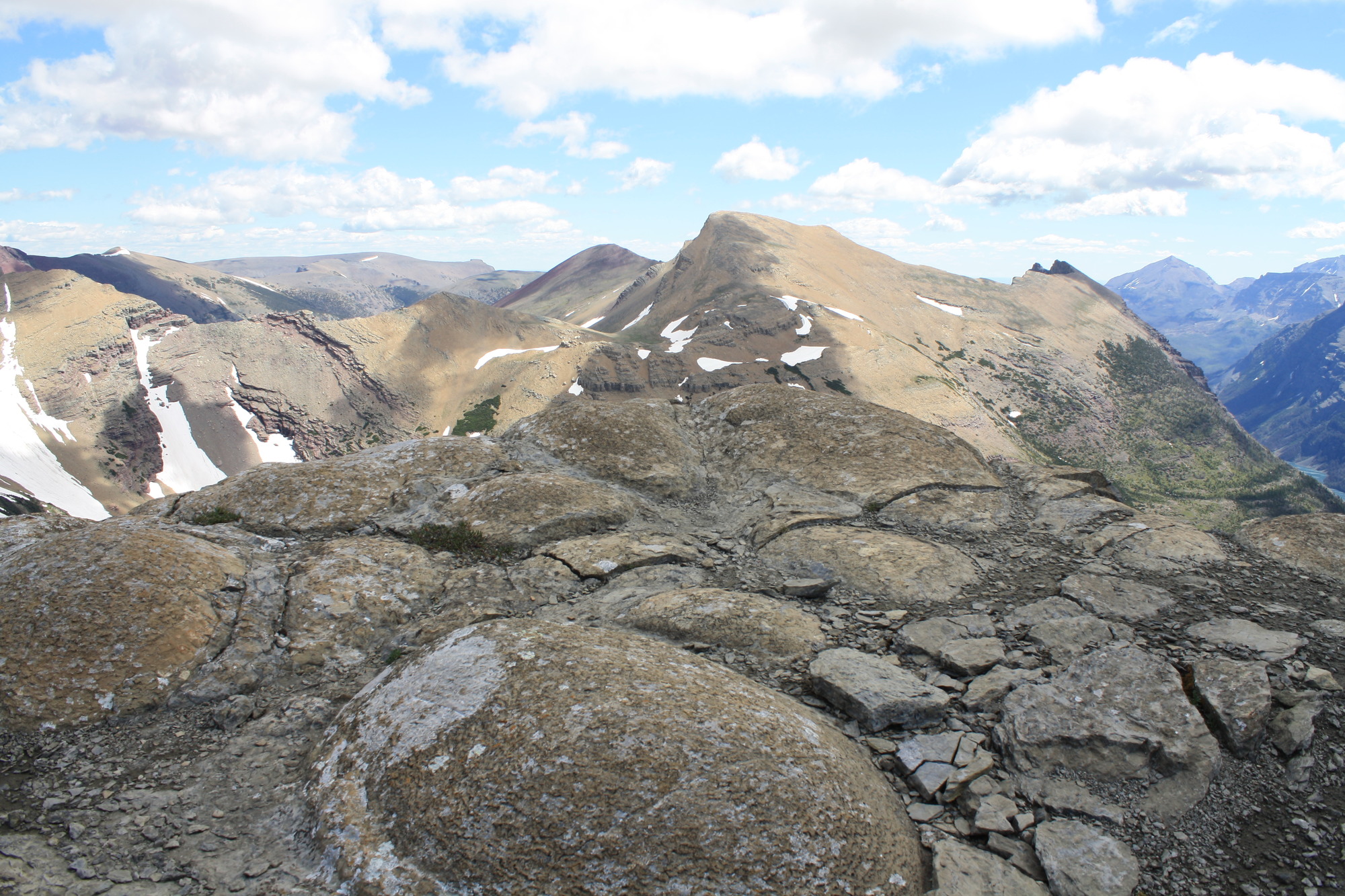 rough rocky mounds in the foreground with mountain peaks in the background. 