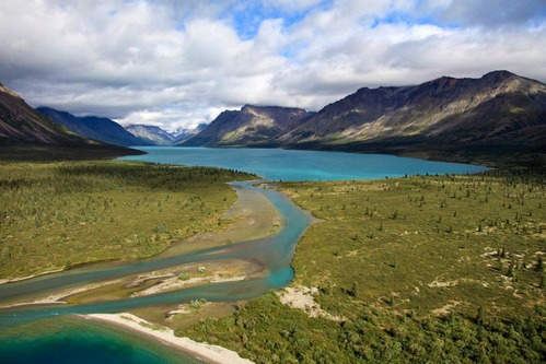 thin stream connects two brilliantly turquoise lakes, surrounded by mountains