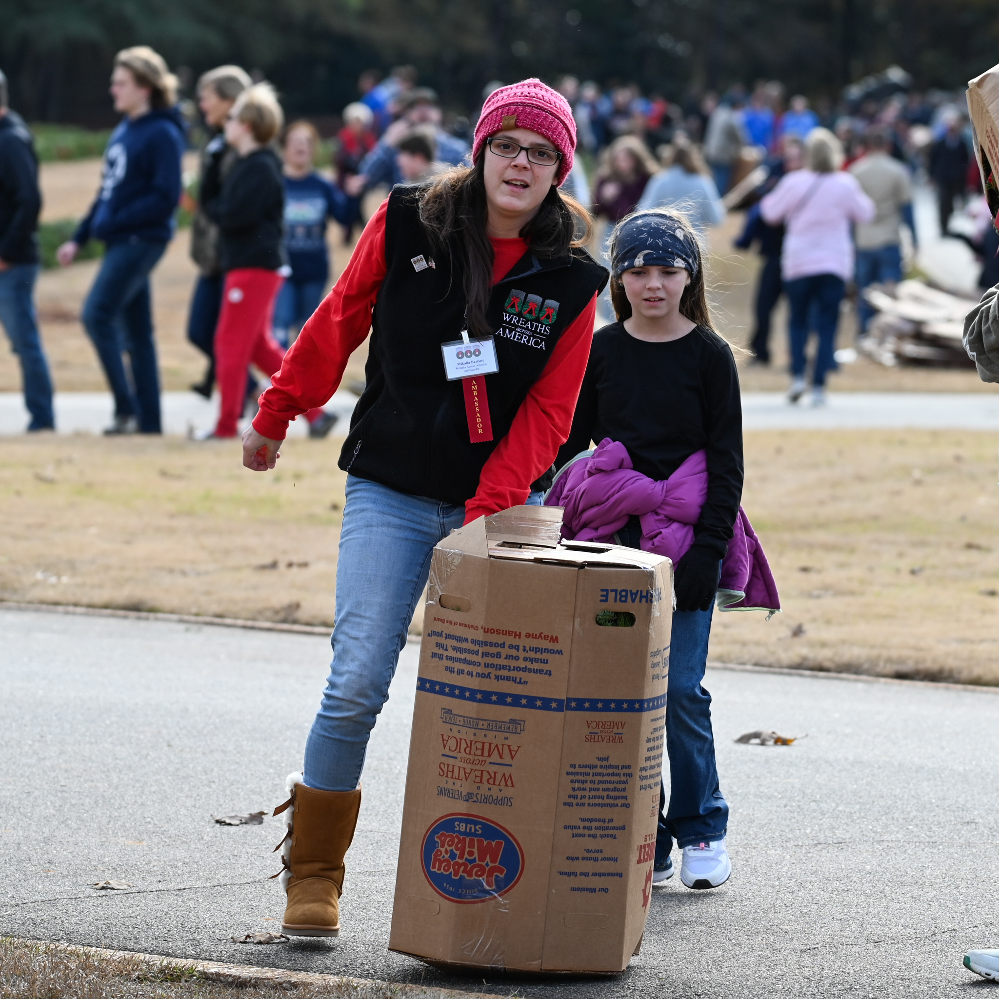 Volunteers carrying a box of wreaths.