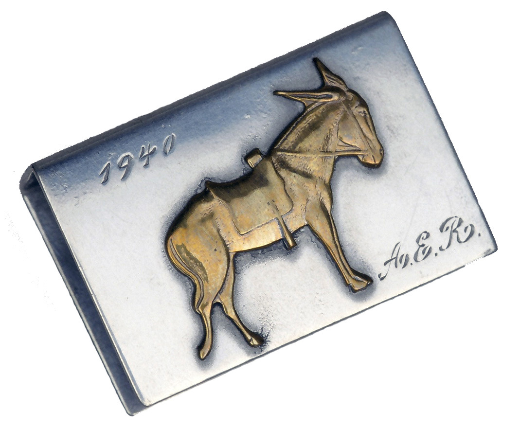 A metal form with three open sides. A brass donkey is fixed to the top and it is engraved "1940 A.E.R."