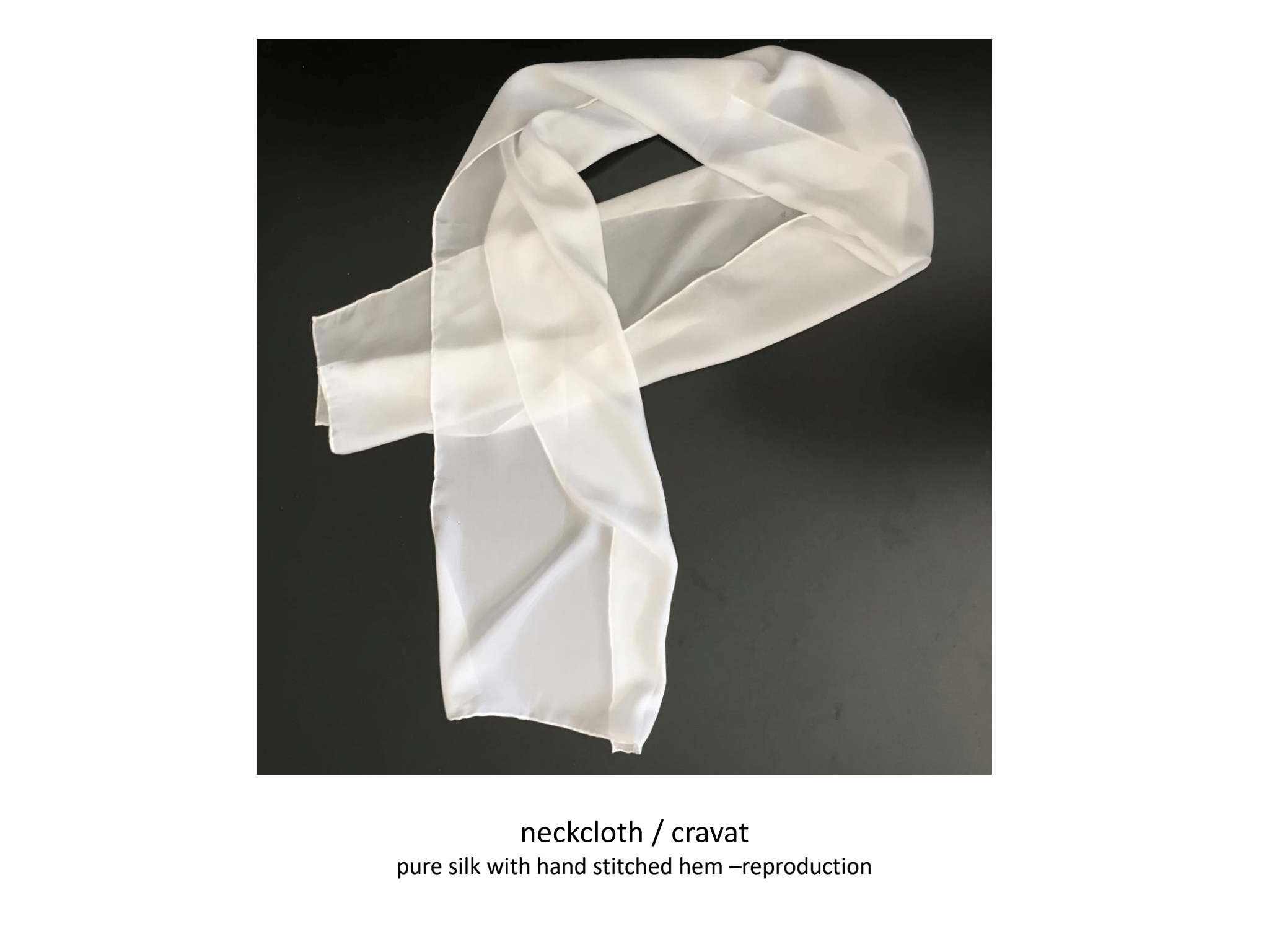A long, rectangular piece of white linen cloth arranged on a black table in the shape of a loop