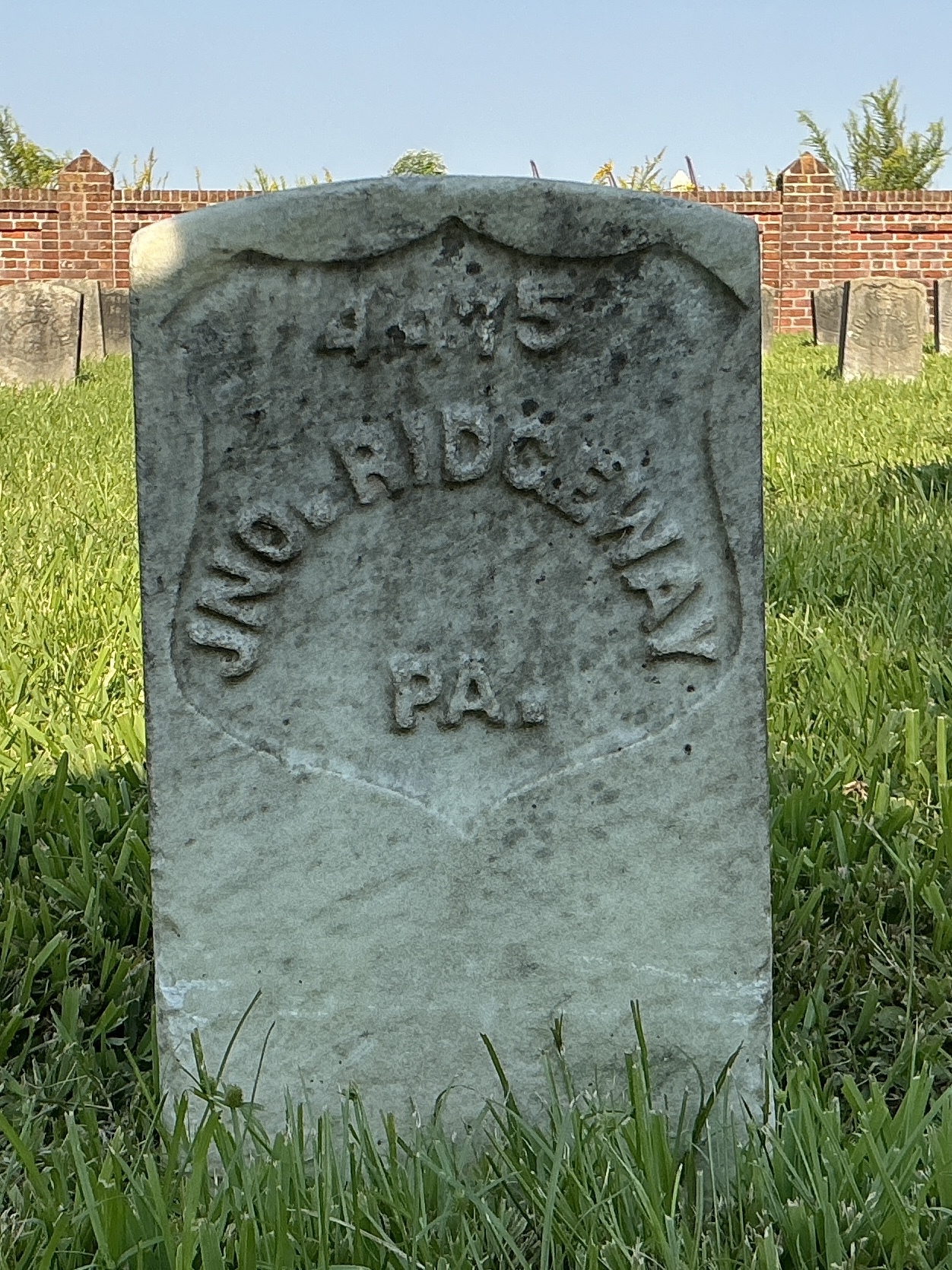 Front of historic upright marble headstone with recessed shield face.