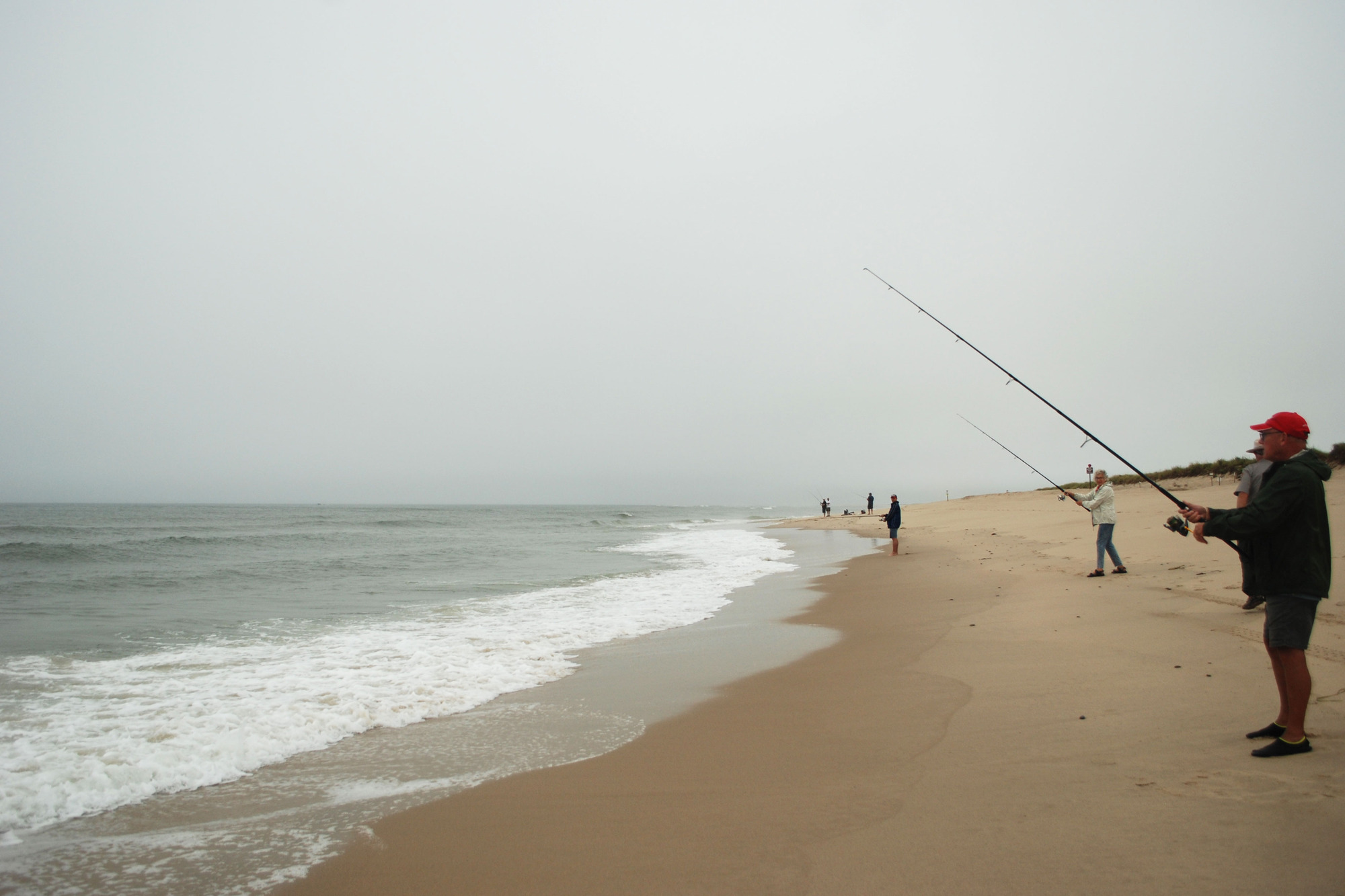 A group of people fish off the coast of Coast Guard Beach