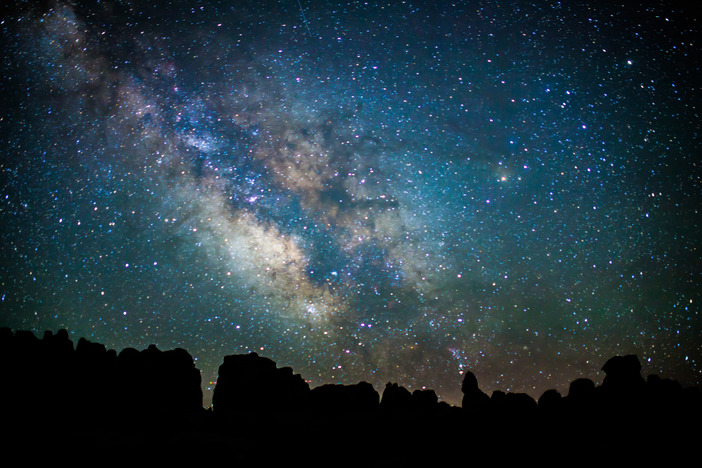 the Milky Way above silhouetted rock pinnacles