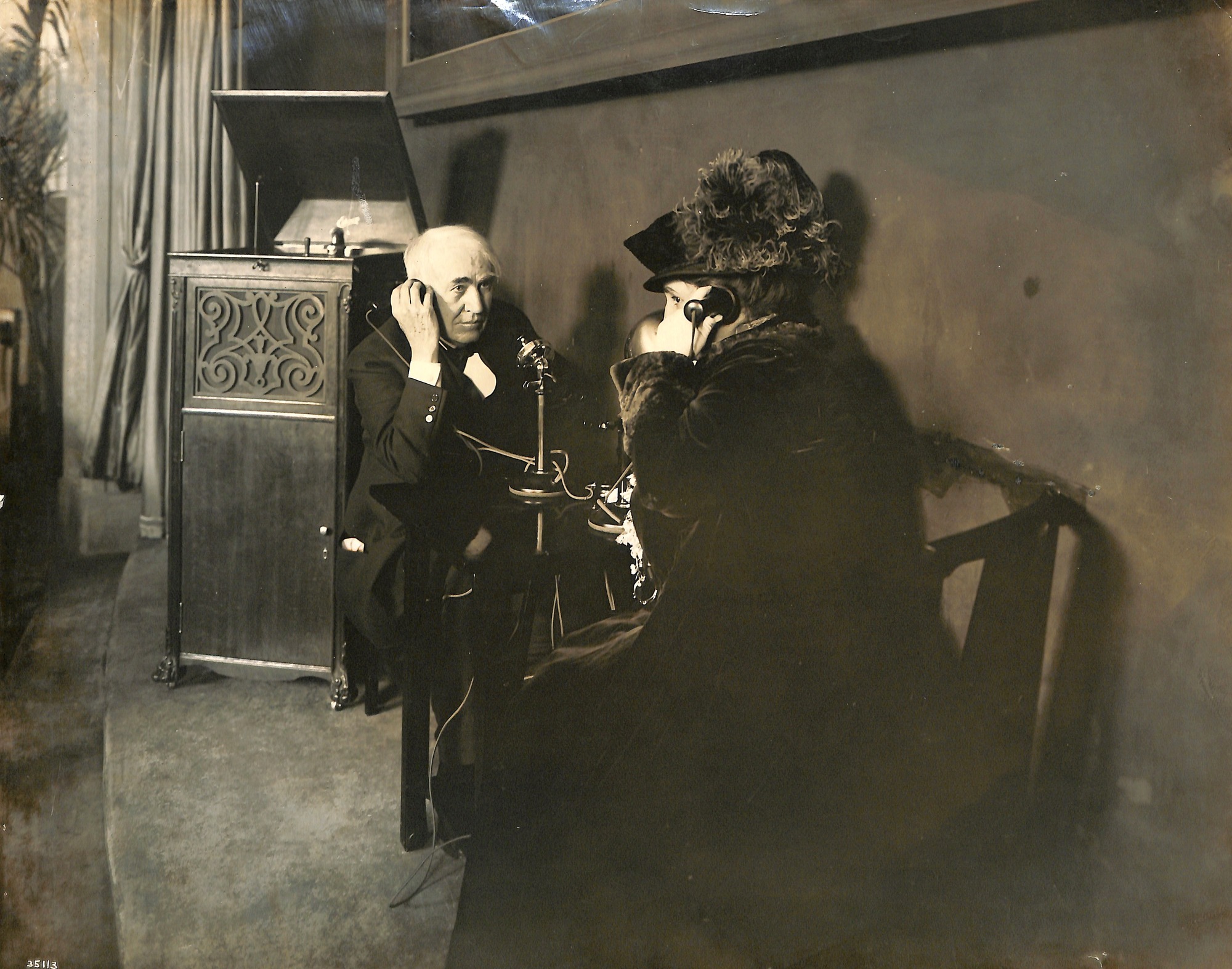 Thomas Edison and Mina Edison at the AT&T Palace of Liberal Arts, exposition grounds in San Francisco, listening by telephone to a Diamond Disc Phonograph being played in West Orange.
