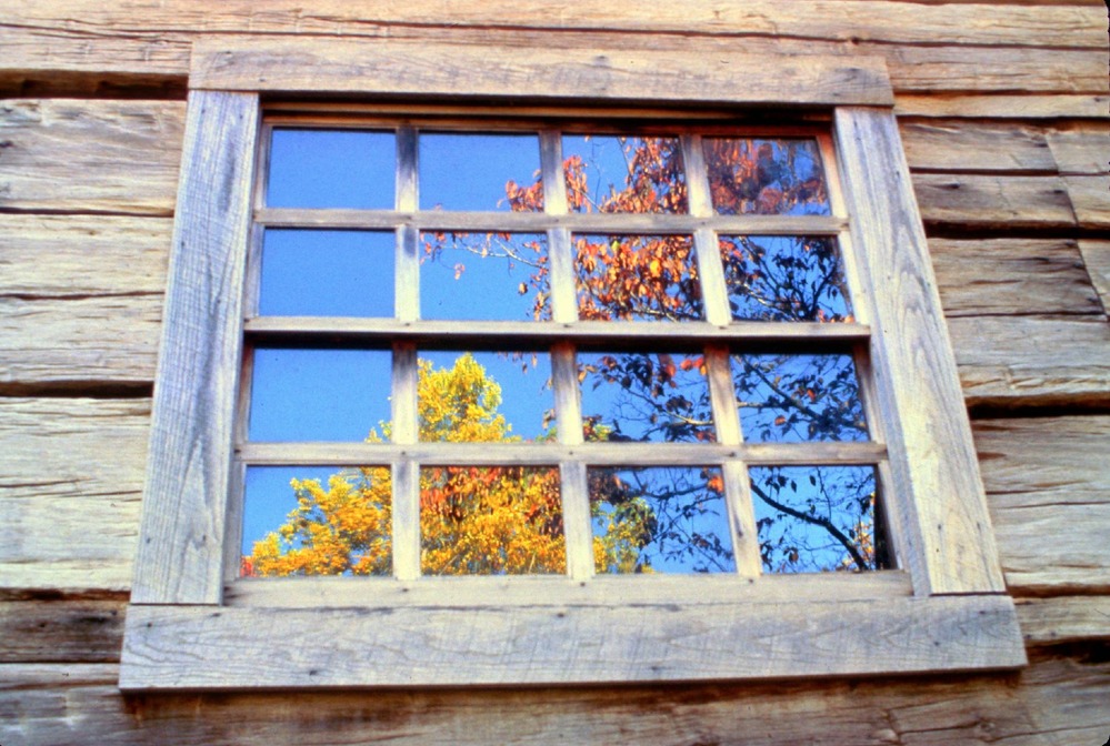 Fall colors reflected in the window of Noah "Bud" Ogle's log house.