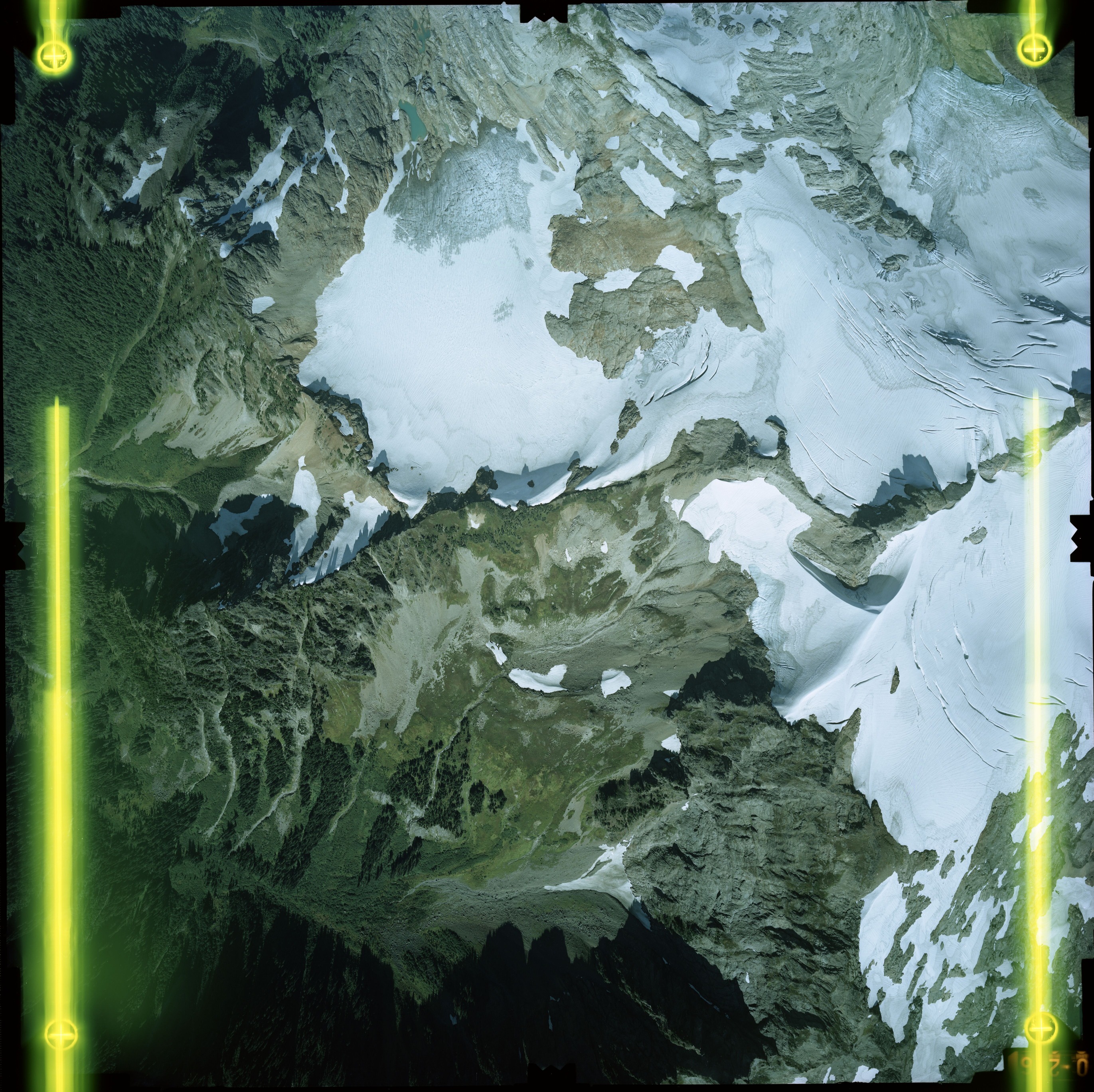 Color aerial photograph of glacier on mountain peak.