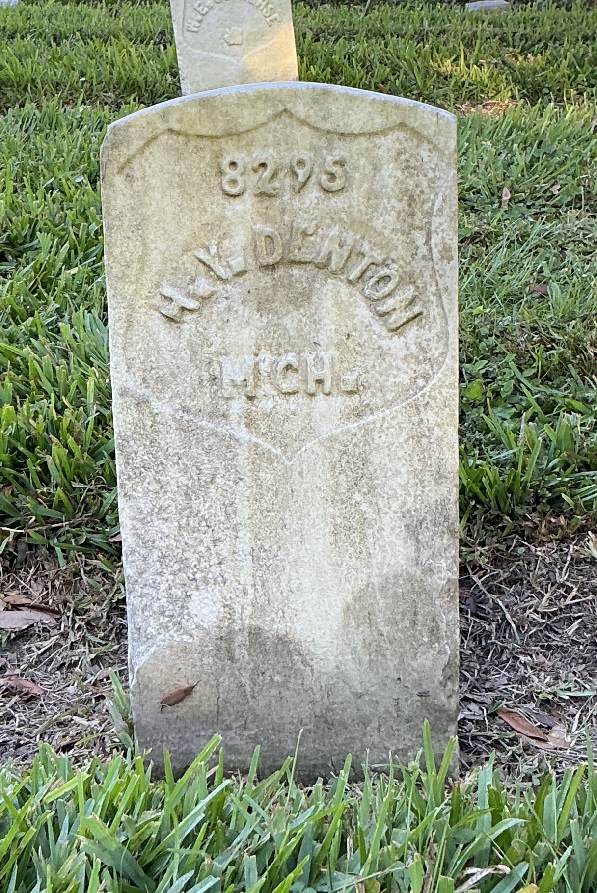 Front of historic upright marble headstone with recessed shield face.