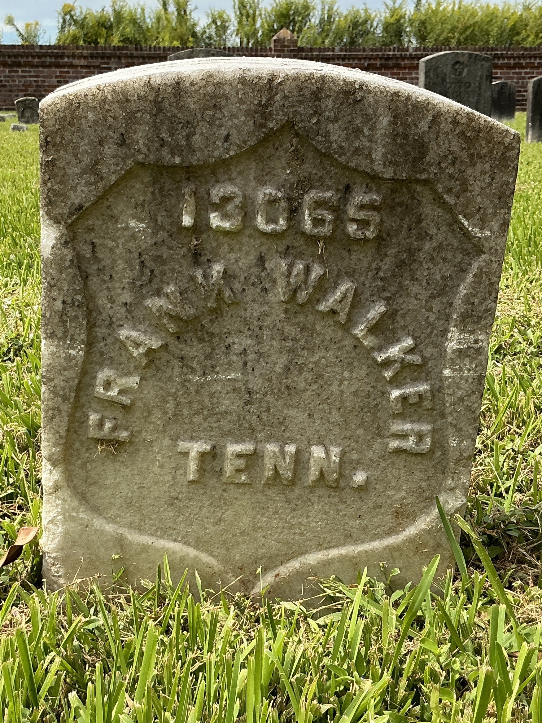Front of historic upright marble headstone with recessed shield face.
