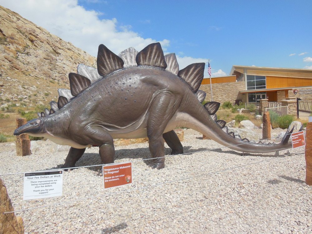 Brown stegosaurus stature on grey rocks 