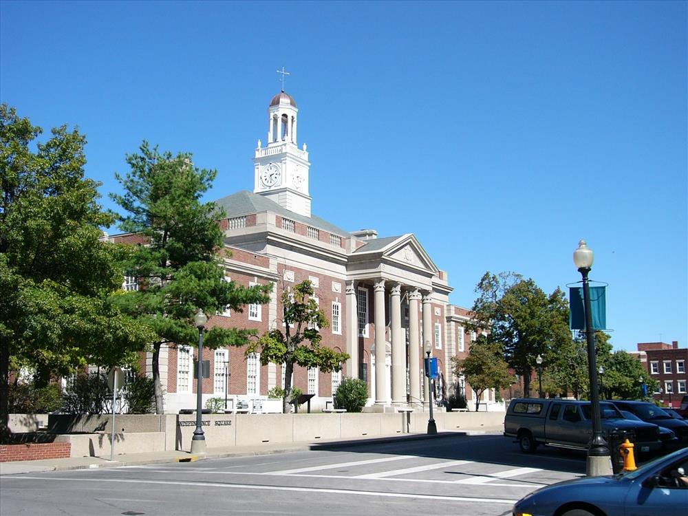 A brick building with a clock tower next to a road.