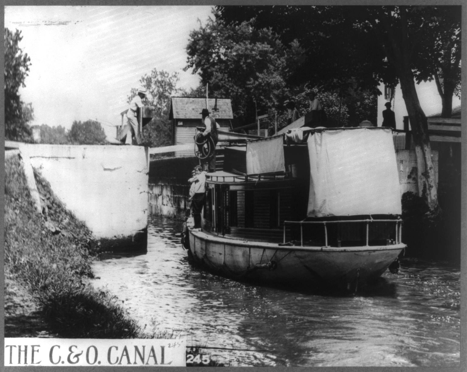 A canal boatman prepares to hand off the snubbing lines to a lock keeper.