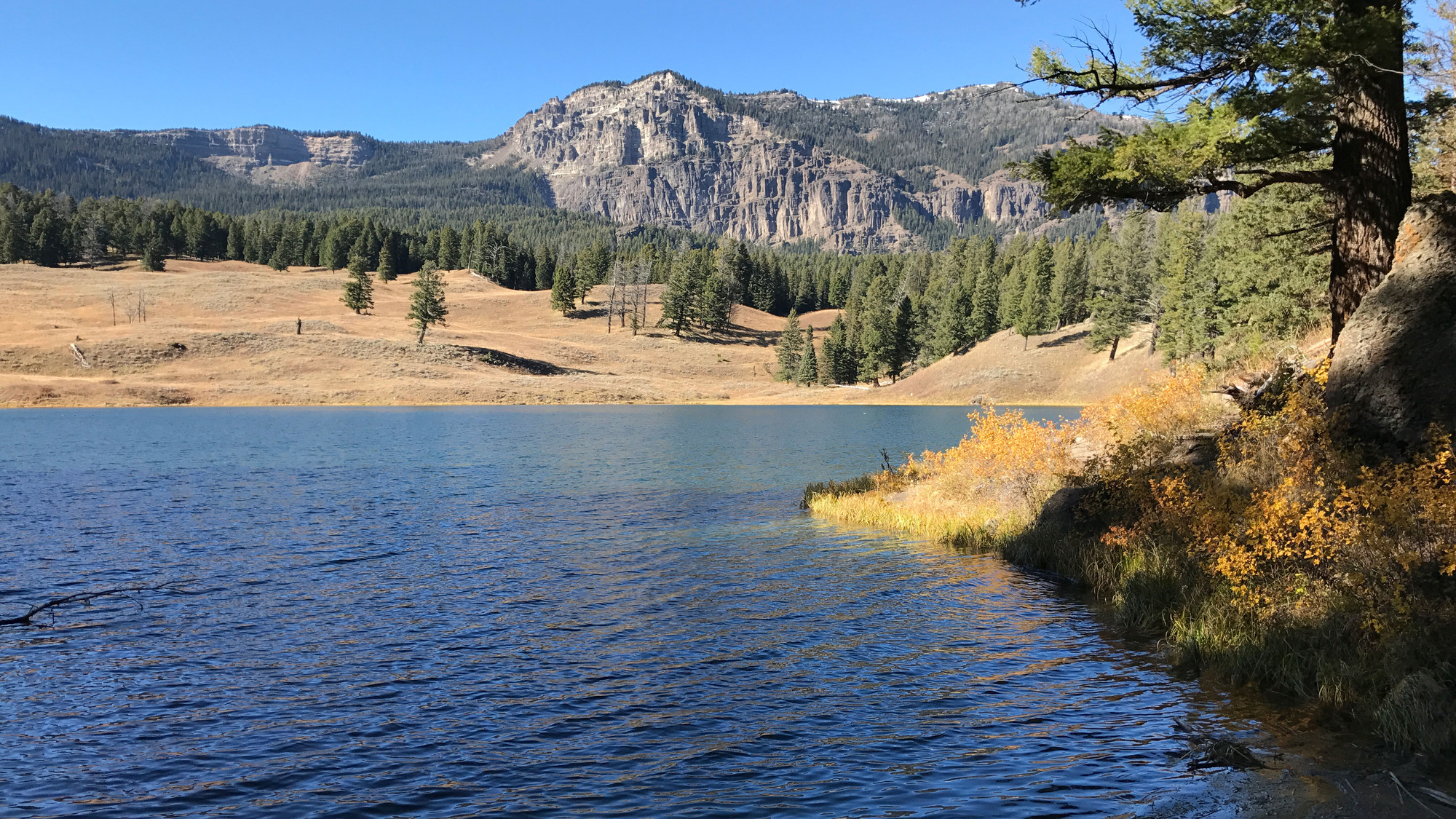 Fall colors surround the lake with a mountain in the background.