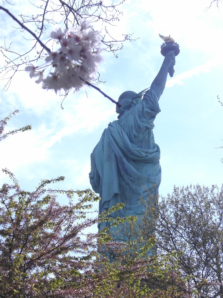 The statue keeps colorful company with flowering trees during spring