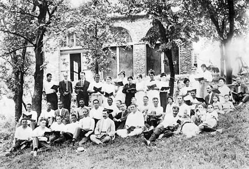 From 1909-1968, John Brown Fort stood on the site of Storer College on Camp Hill in Harpers Ferry. In this circa 1915 photograph, Storer College students, faculty members, and their families pose in front of the fort during an evening choral session. Year: 1915. Image Credit: Historic Photo Collection, Harpers Ferry NHP.