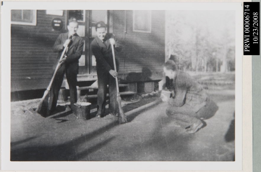 Malinowski and Krishi sweeping a area. Tarby taking a picture.