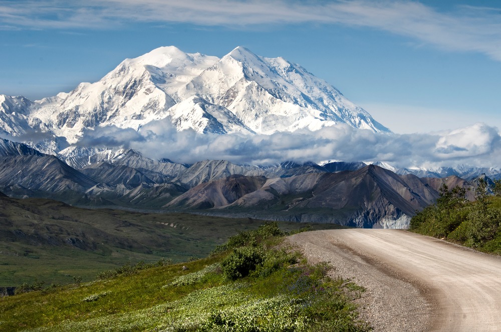 huge snowy mountain looms over smaller mountains