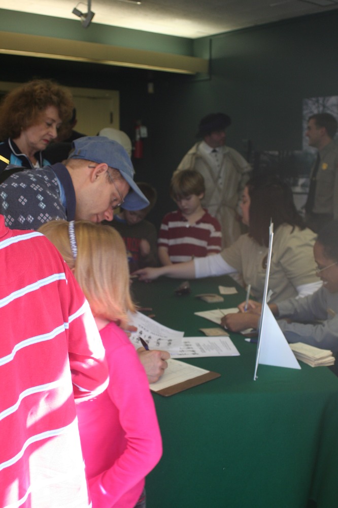 New recruits sign enlistment papers and accept their bounty in continental dollars.