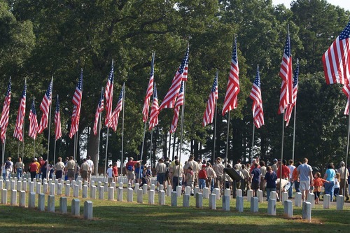 Volunteers gather to begin placing flags on graves in the National Cemetery at Andersonville National Historic Site