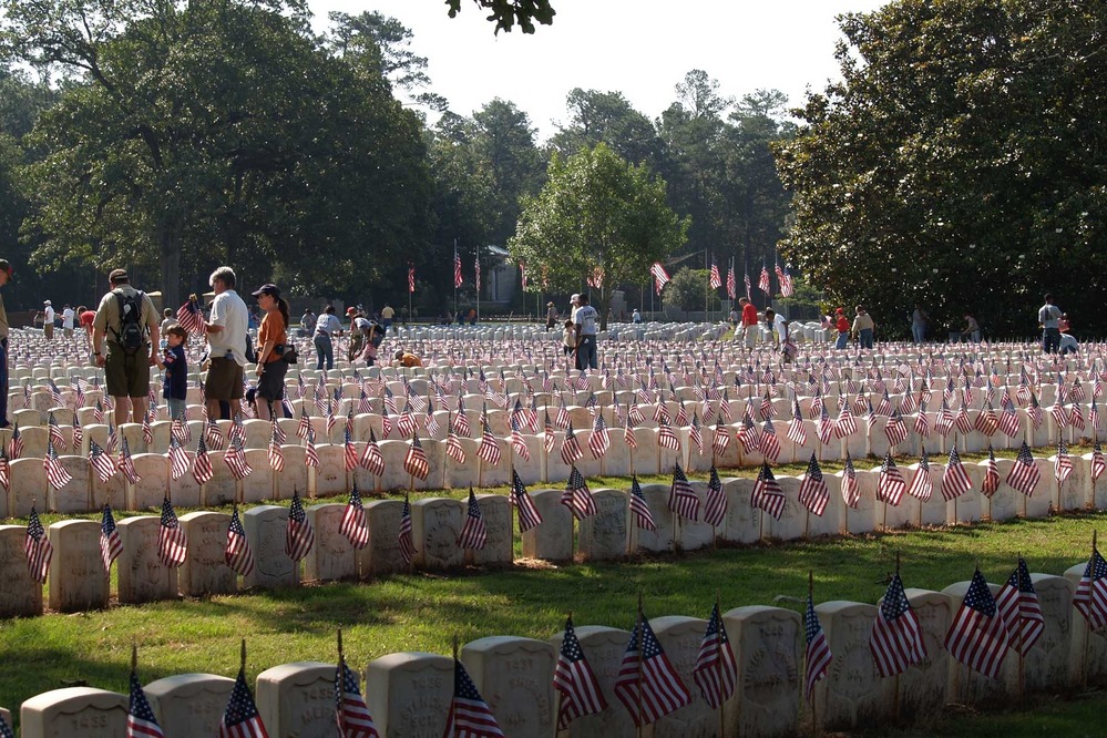 Cub Scouts place flags on Civil War graves in the National Cemetery at Andersonville National Historic Site