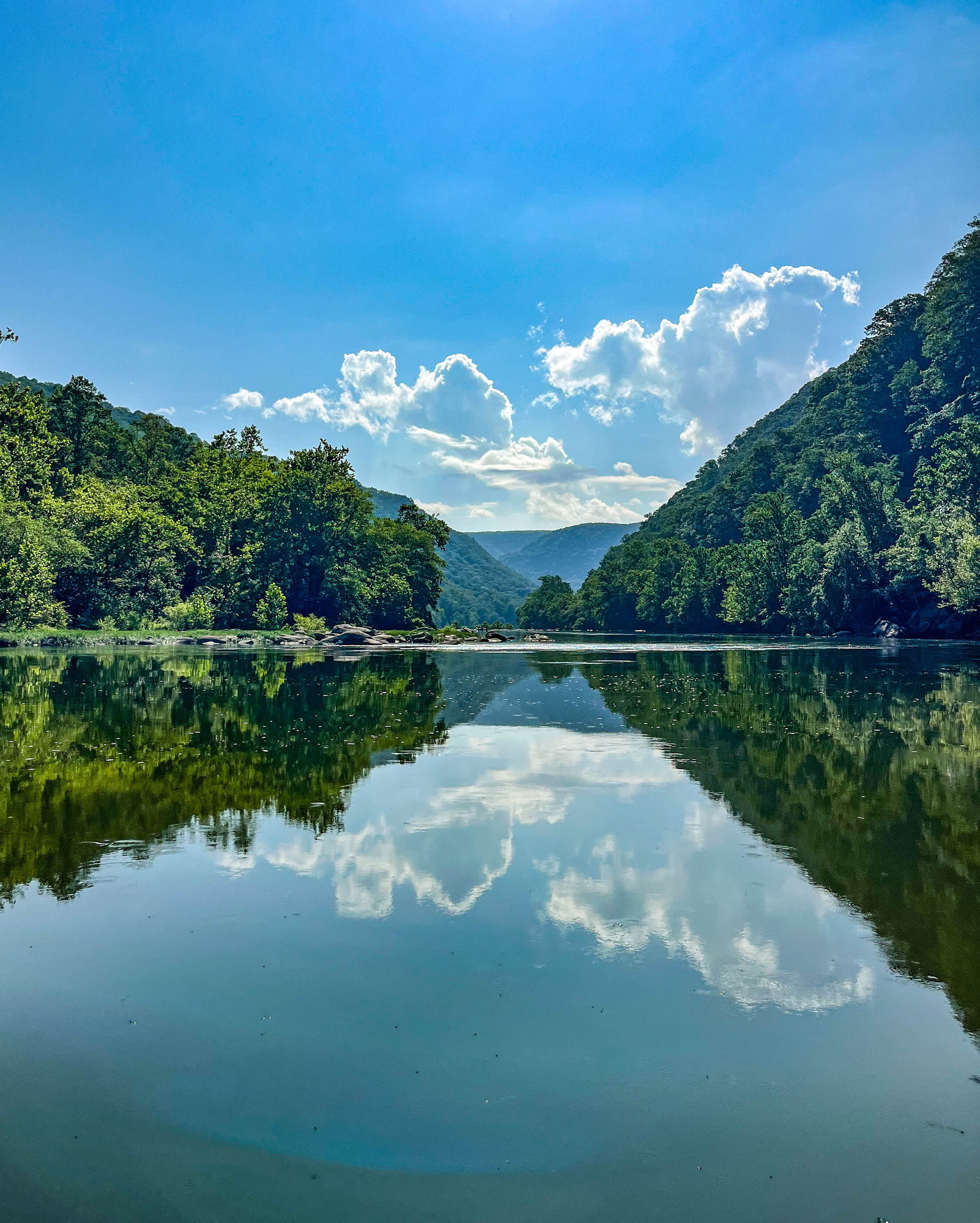 River lined with tree-covered ridges