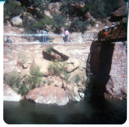 Men working on trail by the new Grotto footbridge. Overview of stone abutment for bridge and trail along Virgin River.