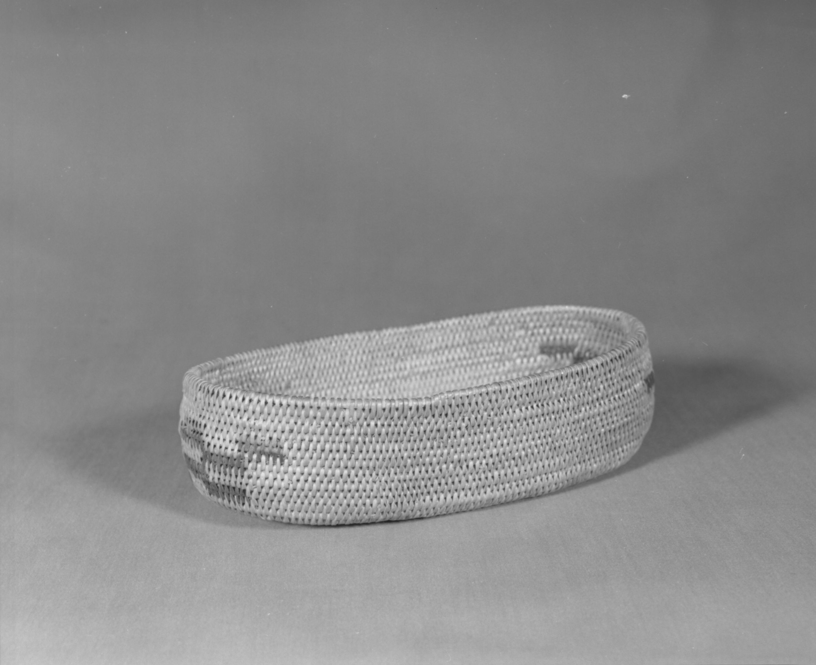 Private Collection. Object: Miwok basket. Dimensions: 8-3/4 x 5 x 2 1/2". Materials: Bull pine and bracken fern root. Technology: Start appears to be made by bending and wrapping sewing strands. Single rod, fag ends trimmed on work face, moving ends trimmed on interior. Leftward coil direction. Collection History: Made by Matilda, a Sonora Miwok, c. 1920. Photographed by Michael Dixon. Catalogued by Craig Bates and Barbara Beroza. Yosemite Collections, National Park Service.