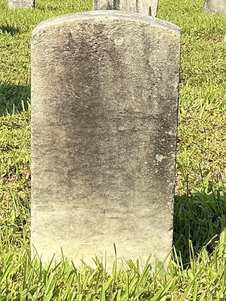Back of historic upright marble headstone with recessed shield face.