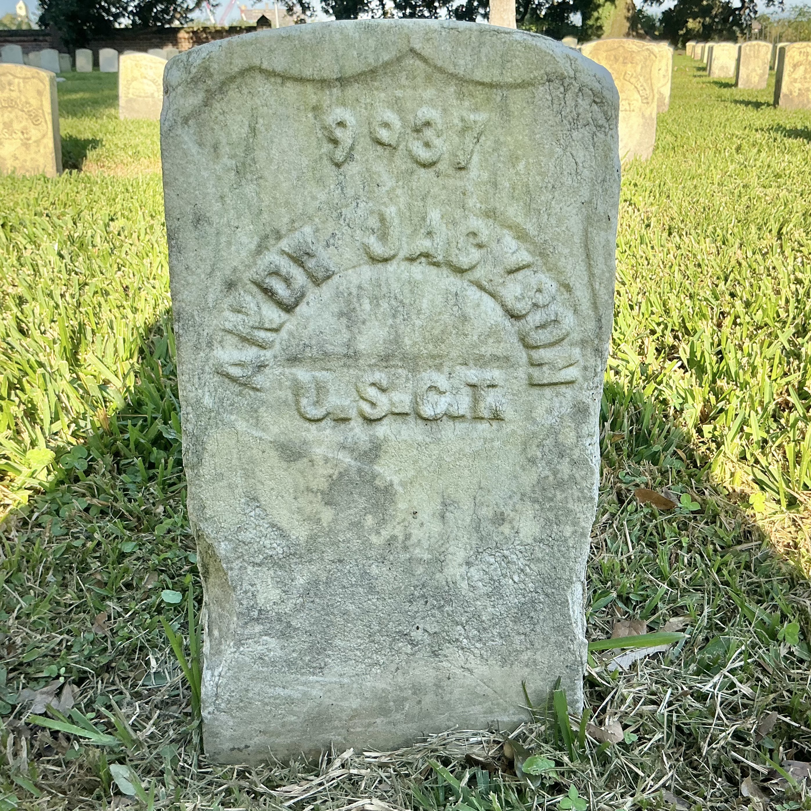 Front of historic upright marble headstone with recessed shield face.