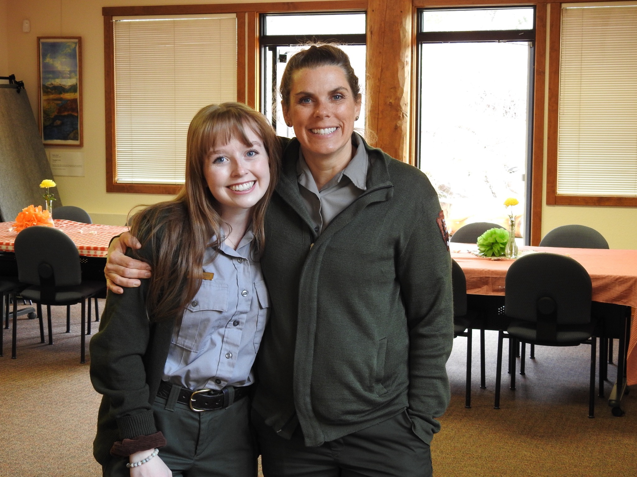 ROMO Volunteer Program Management staff members, Jordan Downie and Sarah Corning. Two female Park Rangers hug and smile for the camera. 